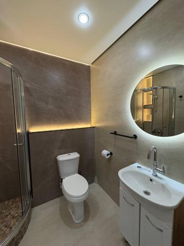 une salle de bain avec toilettes, lavabo et miroir dans l'établissement Апартаменты в 10 минутах от аэропорта Apartments 10 minutes from the airport, à Astana