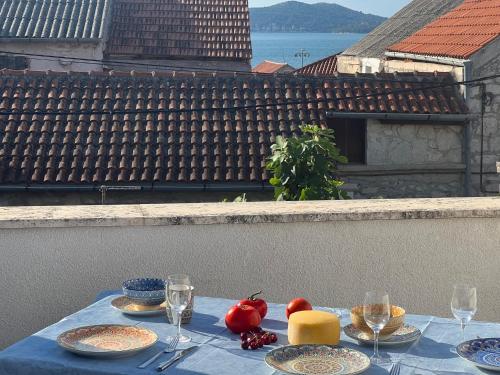 a table with plates of food on top of a balcony at Ferienhaus Insel Murter Vivaldi/Stonehouse Betina in Betina