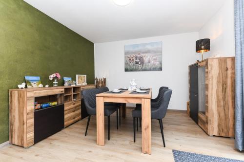 a dining room with a wooden table and chairs at Ferienhaus Moorgeist in Stedesdorf