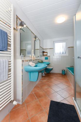 a bathroom with two sinks and two mirrors at Ferienhaus Moorgeist in Stedesdorf