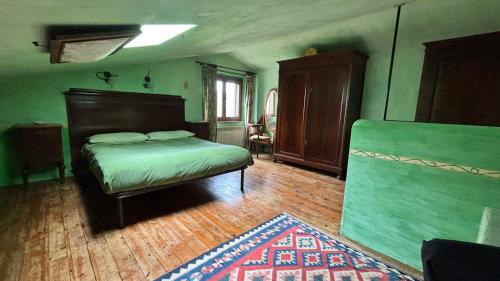 a green bedroom with a bed and a rug at Podere di Maggio - Casa della Nonna in Santa Fiora