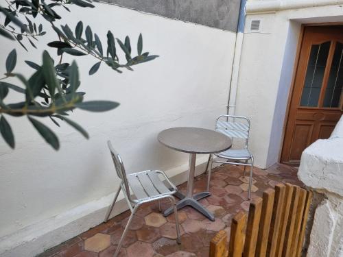 une table et deux chaises sur une terrasse dans l'établissement Danton, à Arles