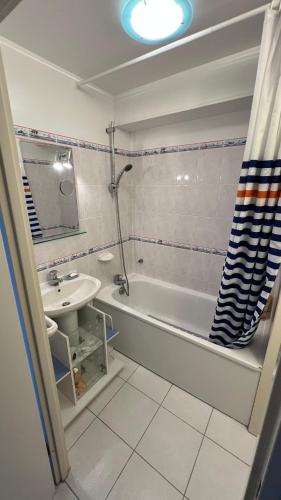 une salle de bain avec une baignoire et un lavabo et une baignoire dans l'établissement Le Jean Bart front de mer, au Crotoy