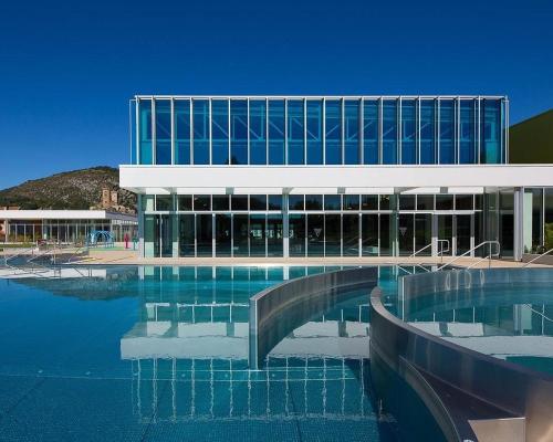 un bâtiment avec piscine d'eau en face d'un bâtiment dans l'établissement MacaIndCo, à Foix
