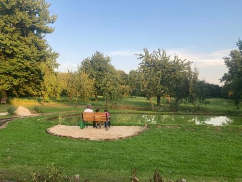 a man and a child sitting on a bench in a park at Ferienwohnung auf idyllischer Hofanlage in Lippe in Blomberg