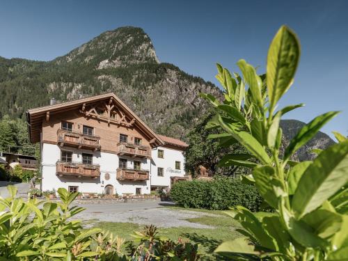 a hotel with a mountain in the background at MYALPS Mühlhof inklusive Sauna in Oetz