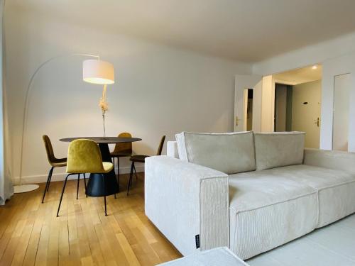 Una sala de estar con un sofá blanco y una mesa. en Le RUTHENE, en Rodez