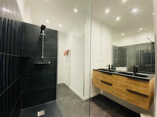 Un baño con ducha de cristal y lavabo. en Le RUTHENE, en Rodez