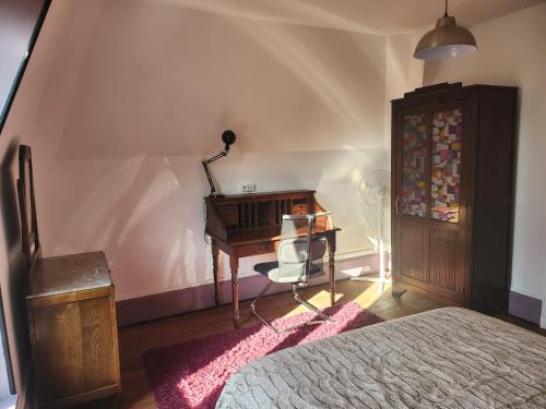 a bedroom with a desk and a chair next to a bed at Appartement atypique - 2 chambres - rue calme dans centre ville in Sedan