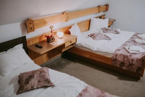 a bedroom with two beds and a desk with a lamp at Villa Yajima in Predeluţ