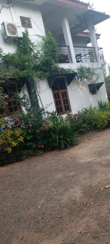 a white building with windows and flowers in front of it at Samudra Luxe Resort in Habarana