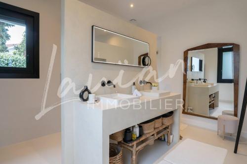 une salle de bain avec deux lavabos et un miroir dans l'établissement Villa Augusta – Biarritz Phare, à Anglet