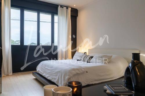 une chambre avec un lit et une grande fenêtre dans l'établissement Villa Augusta – Biarritz Phare, à Anglet