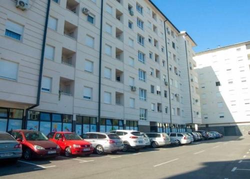a row of cars parked in front of a building at Hedonist Centar 7 Luxury Apartments in Doboj