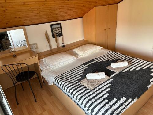 a bedroom with a bed with a black and white blanket at Ruvo Apartman 4 in Orebić