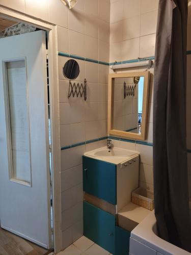 ein Badezimmer mit Waschbecken und Spiegel in der Unterkunft Gîte en campagne à 30 min de la mer in Pédernec