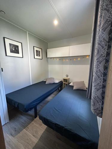 - 2 lits dans une chambre avec des draps bleus dans l'établissement le m130, à Bias