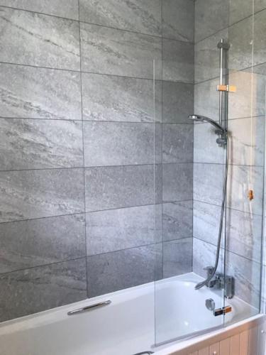 a bathroom with a shower with a bath tub at Belmont Chapel Cottage in Acharacle