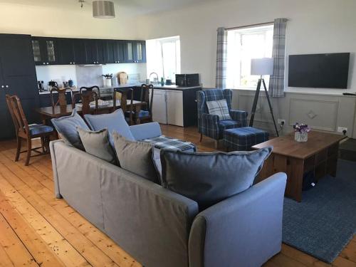 a living room with a couch and a table at Belmont Chapel Cottage in Acharacle