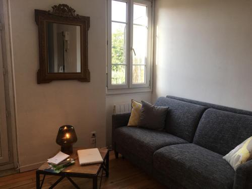 un salon avec un canapé bleu et une table dans l'établissement Very central Toulouse apartment, à Toulouse