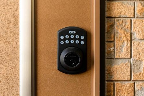 a remote control on a door with a brick wall at Otani gofuku in Fukuoka