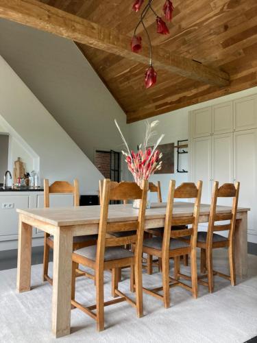 a dining room with a wooden table and chairs at Hoeve Sterrewijk in Aalter