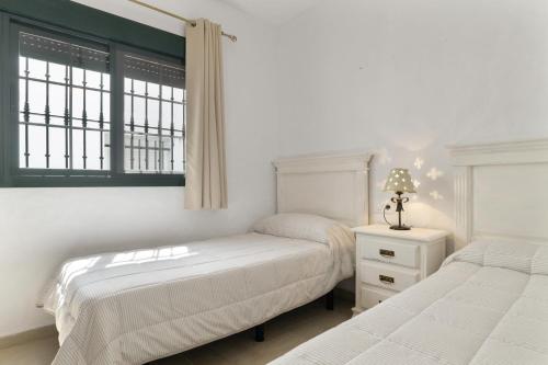 a bedroom with two beds and a window at Casa Huerta 1 in Conil de la Frontera