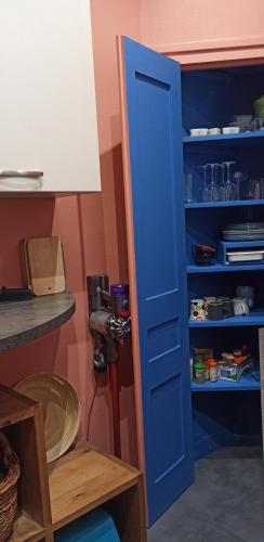 une porte bleue dans une cuisine avec une étagère dans l'établissement Logement cosy au centre ville, à Saint-Brieuc