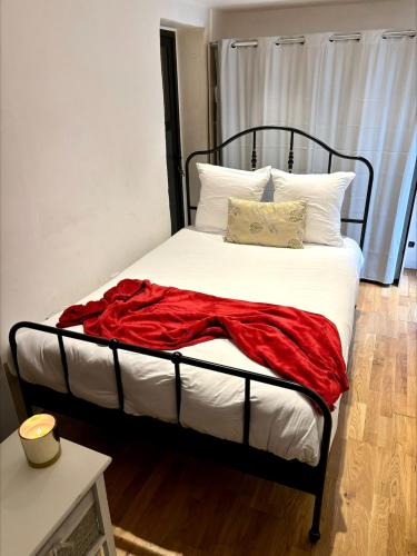 - un lit avec une couverture rouge et des oreillers dans l'établissement Confort, halles et plage à pied Biarritz centre, à Biarritz