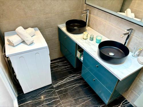 une salle de bain avec un lavabo noir et un miroir dans l'établissement Confort, halles et plage à pied Biarritz centre, à Biarritz