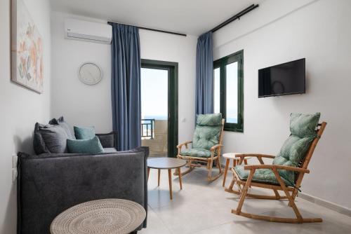 a living room with a couch and chairs and a tv at Blue Horizon Apartments in Stalida