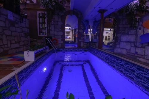 a pool in a house lit up at night at Blue Home, Luxury Villa with Pool in the City Centre in Larisa