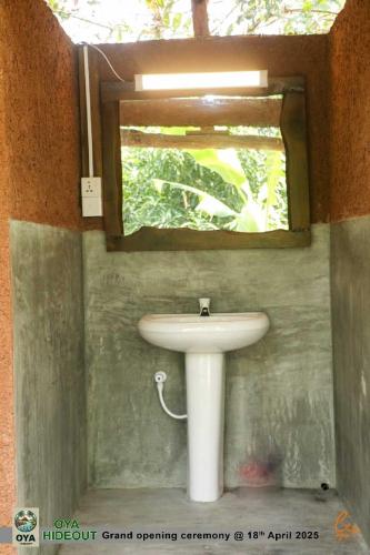 a bathroom with a white sink and a window at Oya hideout in Anuradhapura