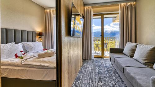 a hotel room with a bed and a couch at Złoty Horyzont VIP - główny budynek - z basenem, siłownią, grotą solną, bawialnią i restauracją by Royal Aparts in Szklarska Poręba