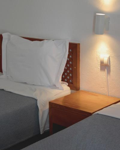 a bedroom with a bed with a pillow and a wooden table at Vegas Residence - Adults Only in Albufeira
