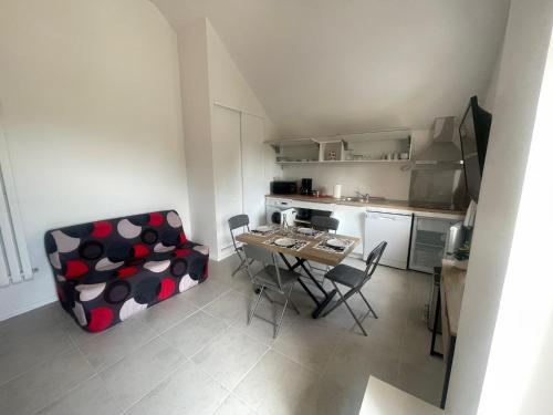 un salon avec une table et des chaises et une cuisine dans l'établissement Le Studio, à Goussainville