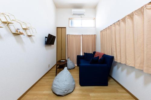 a living room with a blue couch and a window at Otani gofuku in Fukuoka