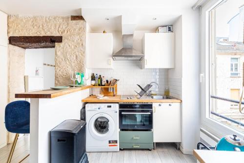 une petite cuisine avec lave-linge et sèche-linge dans l'établissement GuestReady - Charm & Comfort near Canal St Martin, à Paris