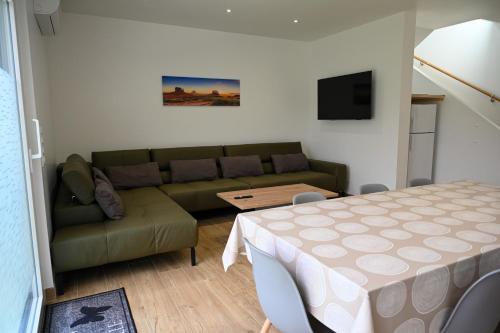 a living room with a couch and a table at Europapark à 11km Maison Soleil climatisé in Friesenheim