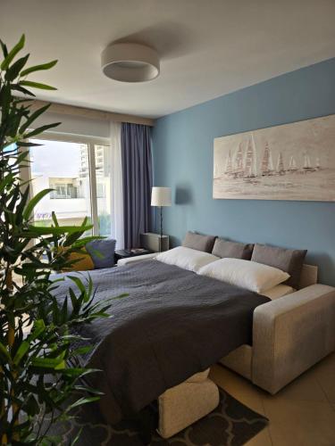 a bedroom with a large bed and a couch at Apartment Belaj SeaSide Resort - Sea view in Umag
