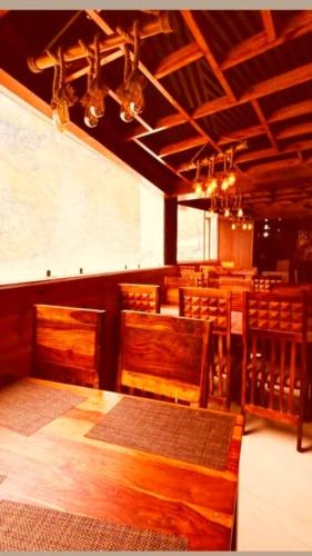 a dining room with a table and wooden chairs at Hotel New Urvashi in Jāmb