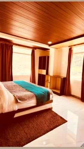 a bedroom with a bed and curtains and a rug at Hotel New Urvashi in Jāmb