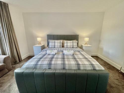 a bedroom with a large bed with two lamps on tables at Holdsworth House Apartments in Killingbeck