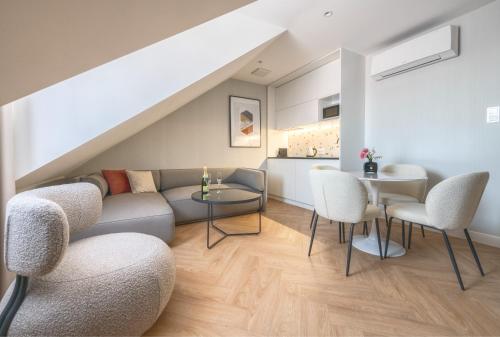 a living room with a couch and chairs and a table at Retro Boutique by NorthSide Apartments in Gdańsk