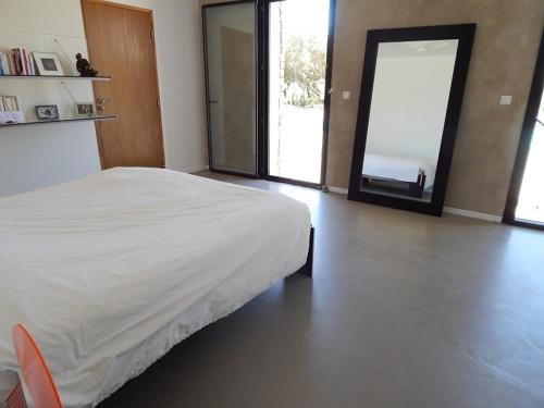 une chambre avec un lit et une porte coulissante en verre dans l'établissement Splendide Villa en bordure de Golf, à Saint-Gély-du-Fesc