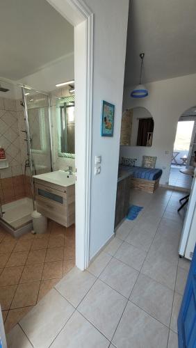 a bathroom with a shower and a sink and a tub at Fantastic View Studios Kythnos in Kithnos