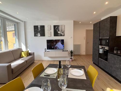 a living room with a table and yellow chairs at Appartamenti TEI Orobic Experience in Premana