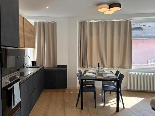 a kitchen with a table and chairs in a room at Appartamenti TEI Orobic Experience in Premana