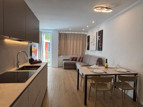 a kitchen and living room with a table and chairs at Appartamenti TEI Orobic Experience in Premana