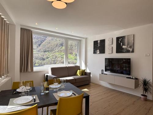 a living room with a dining table and a couch at Appartamenti TEI Orobic Experience in Premana